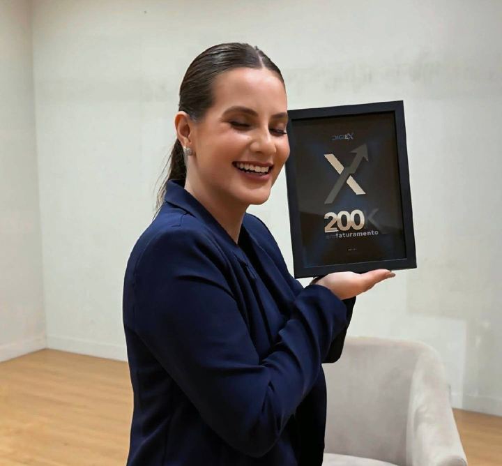 Aluna recebe placa de faturamento no palco do DigiEx