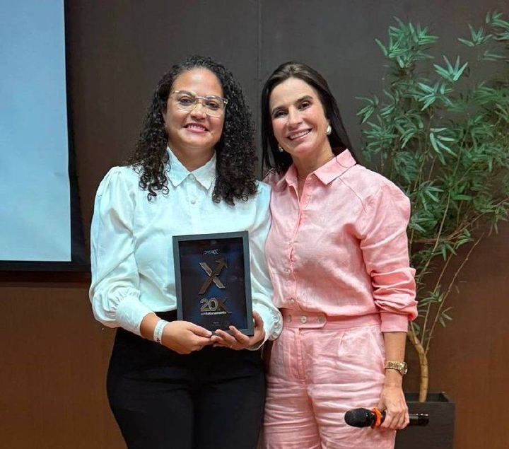 Aluna recebe placa de faturamento no palco do DigiEx