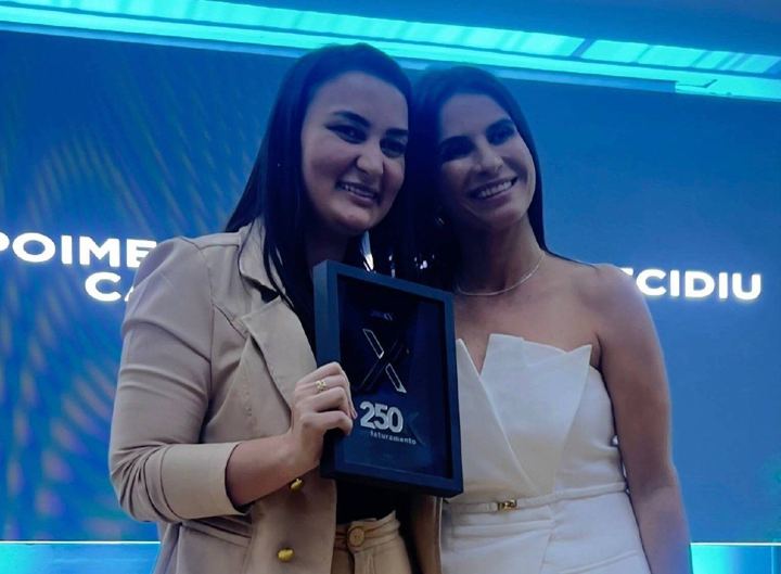 Aluna recebe placa de faturamento no palco do DigiEx