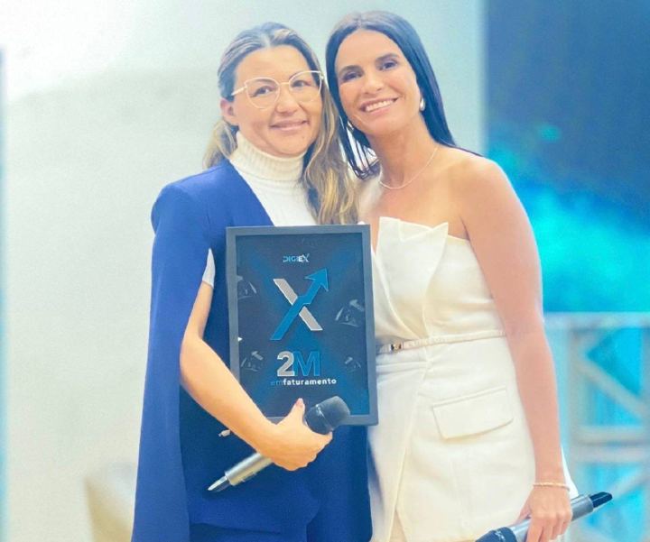 Aluna recebe placa de faturamento no palco do DigiEx
