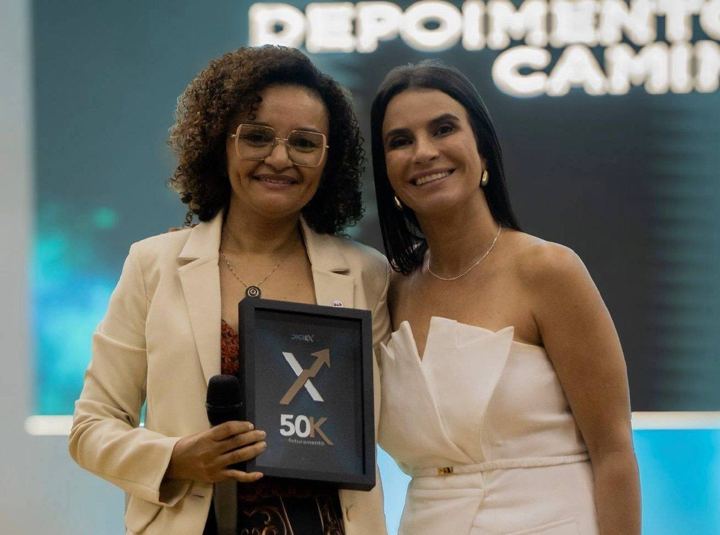 Aluna recebe placa de faturamento no palco do DigiEx