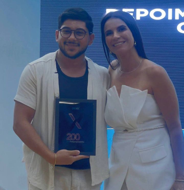 Aluno recebe placa de faturamento no palco do DigiEx