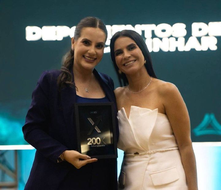 Aluna recebe placa de faturamento no palco do DigiEx
